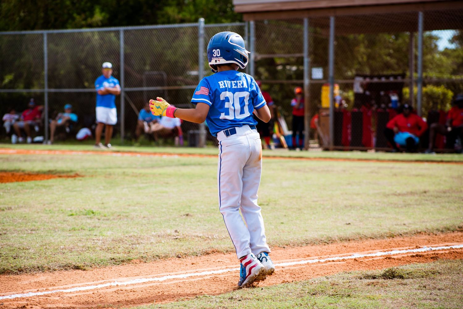 Baseball players in numbered jerseys spread across the infield during a sunny afternoon game.