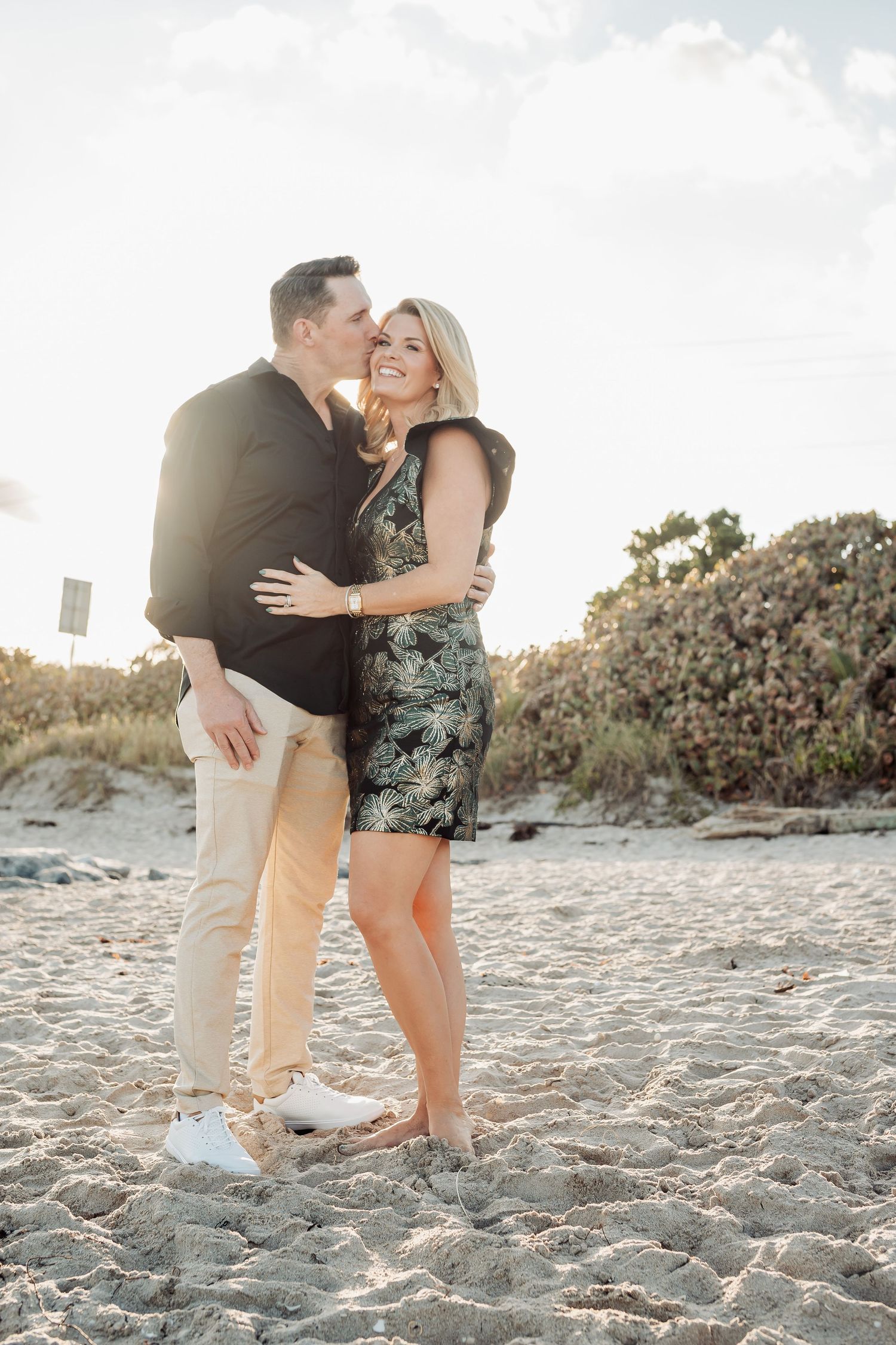 Romantic couple sharing an intimate moment on the beach during sunset.