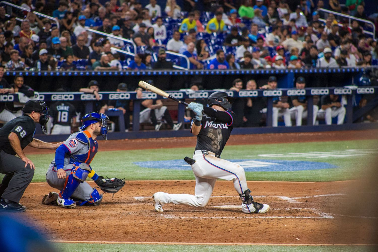 Baseball players sliding into home plate during an intense play at a professional baseball game.