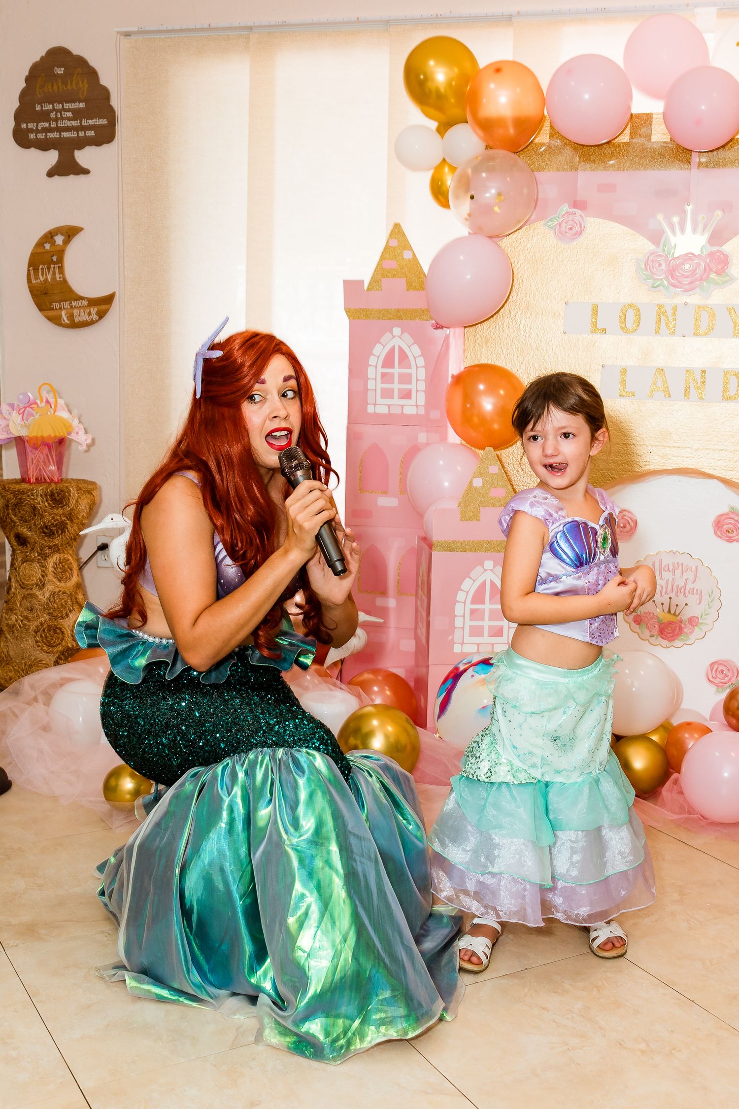 A magical princess-themed birthday party setup with pink and gold balloons and castle decorations.
