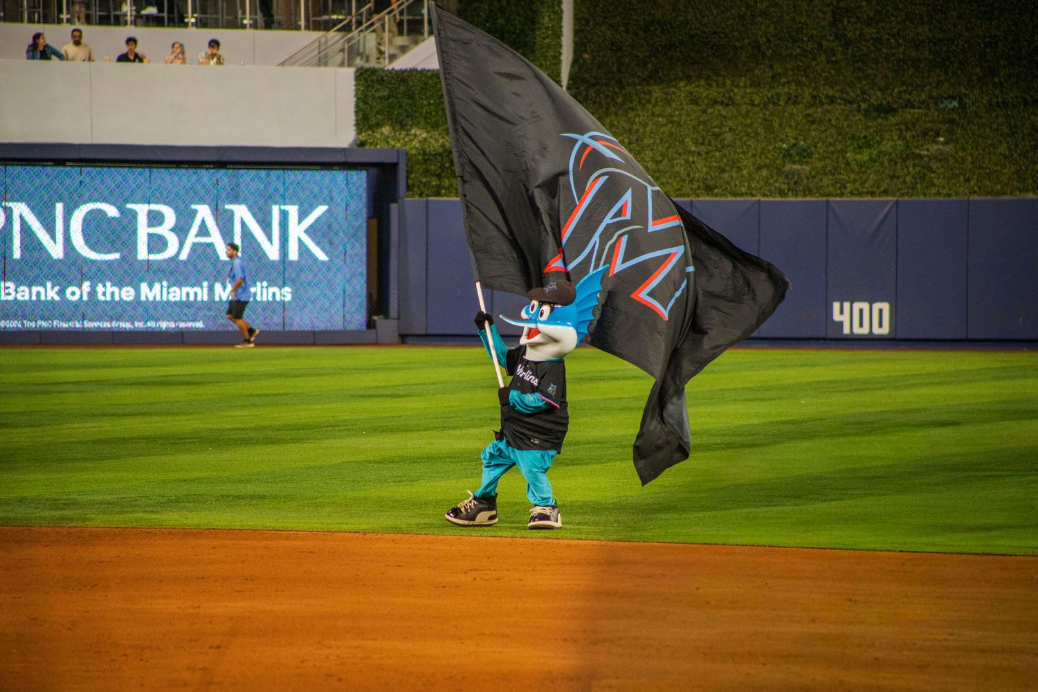 Baseball field with outfield wall and stadium signage visible during a game.