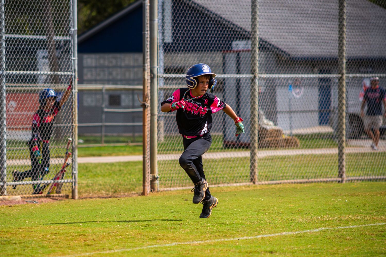 A baseball player runs on the field during a game while wearing a gray and red uniform.