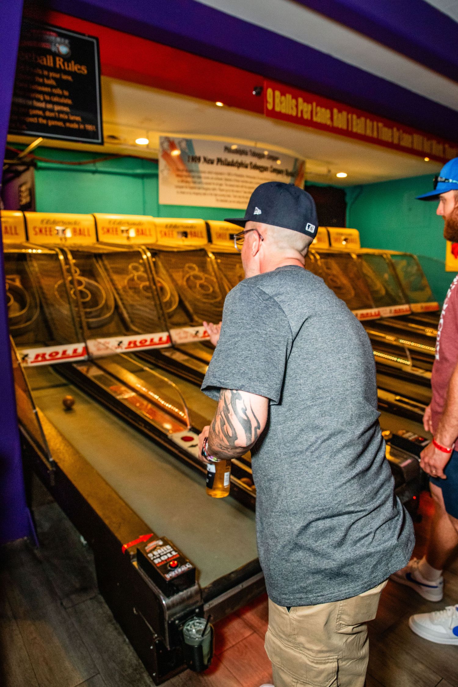 A person playing a classic arcade game machine in an entertainment venue.