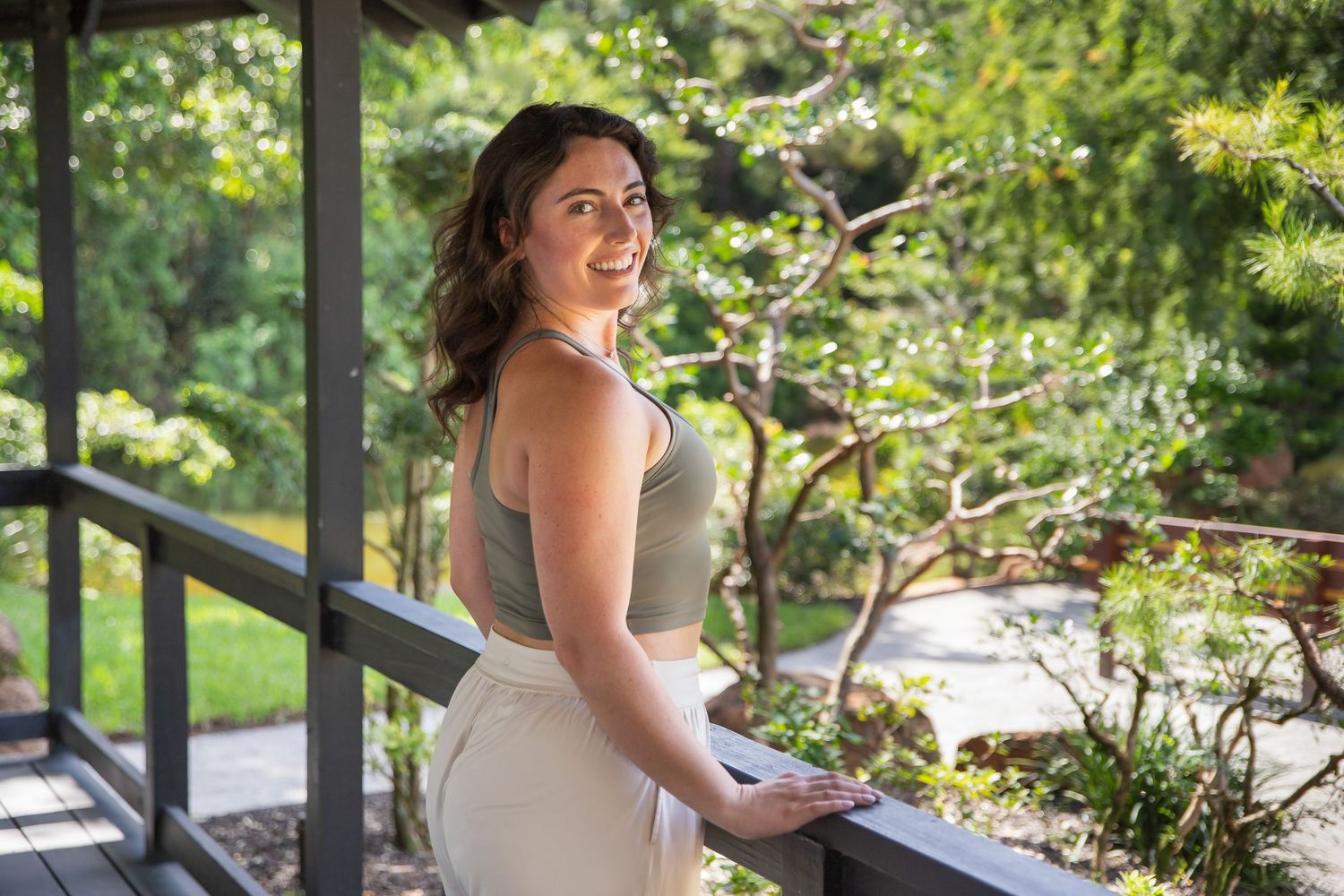A couple in formal attire poses for photos in a lush garden setting during a wedding celebration.