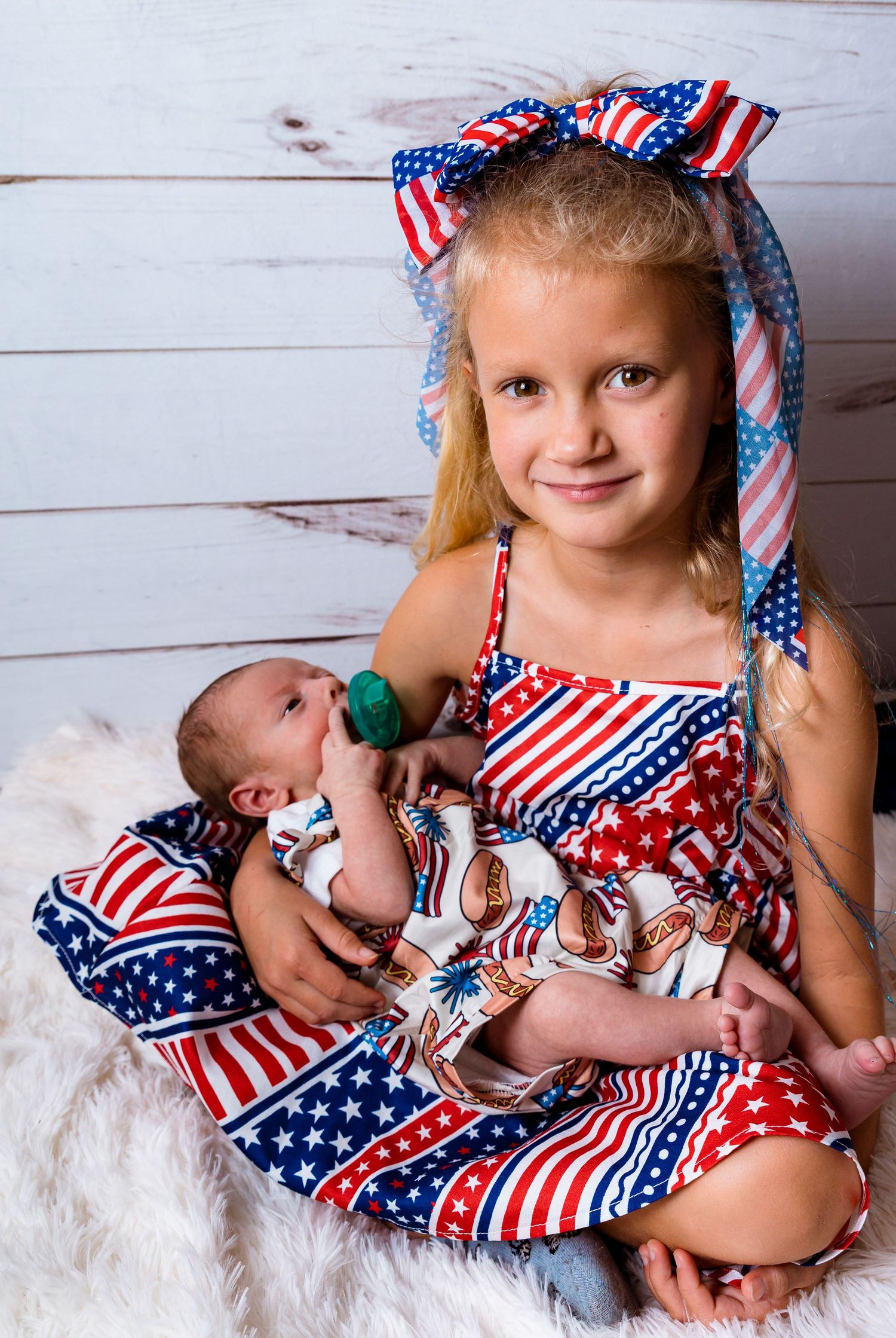 Patriotic American flag themed clothing and accessories in a festive holiday portrait setting.