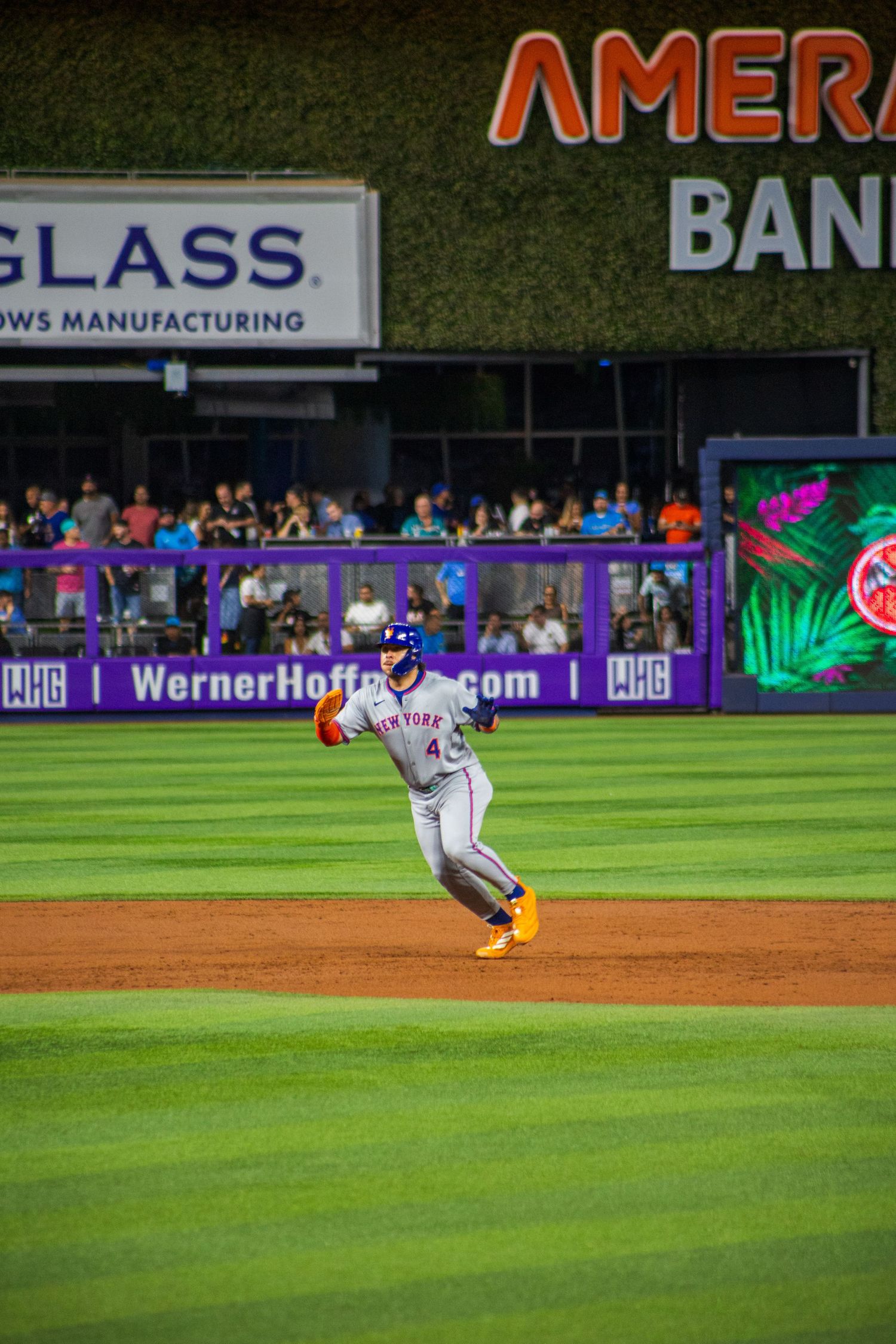 Baseball player sliding into base during intense game action at professional stadium.