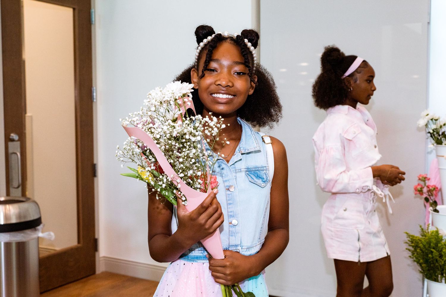 Baby's breath and pink floral arrangements displayed at a celebratory event.