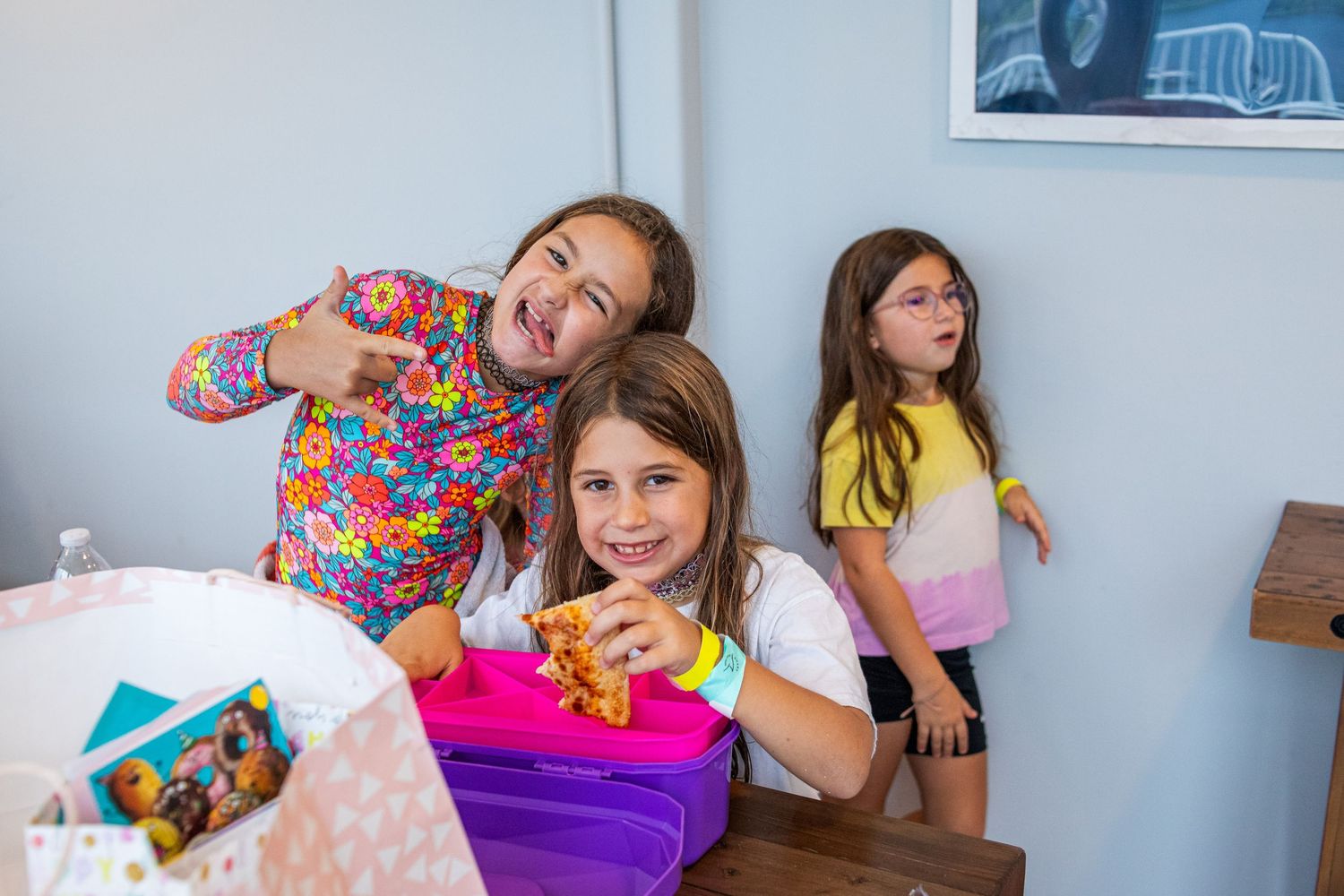 Excited adults enjoying themselves while lying on soft pillows and colorful cushions in a casual playful setting.
