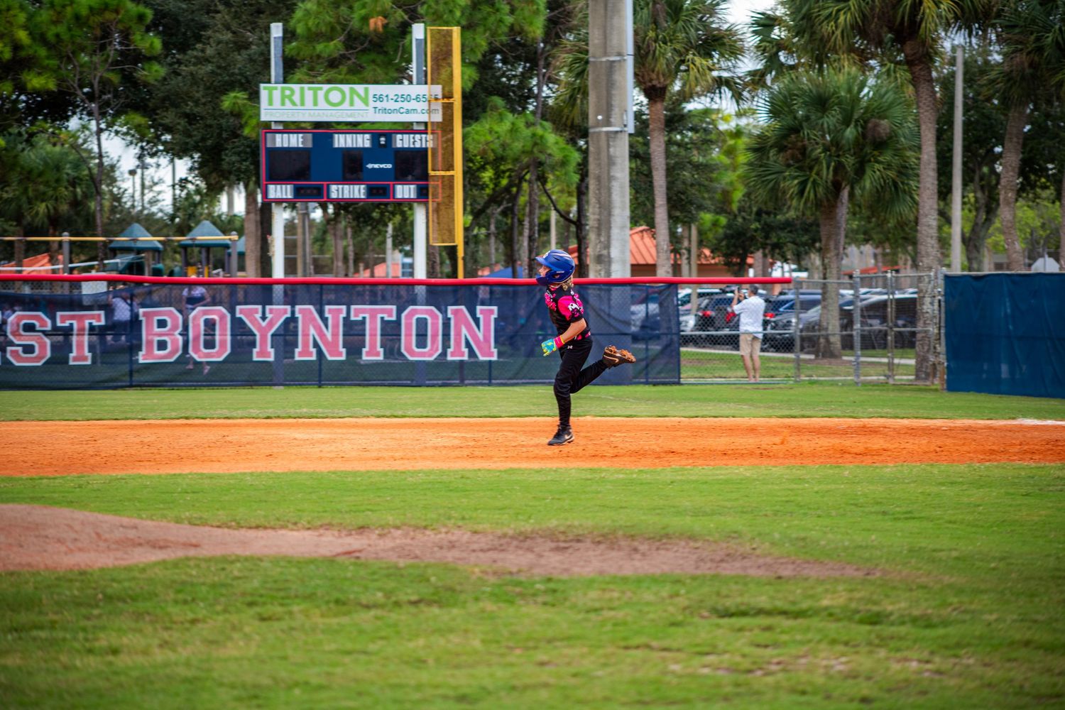 Baseball field with 'ST BOYNTON' signage visible on outfield wall during gameplay.