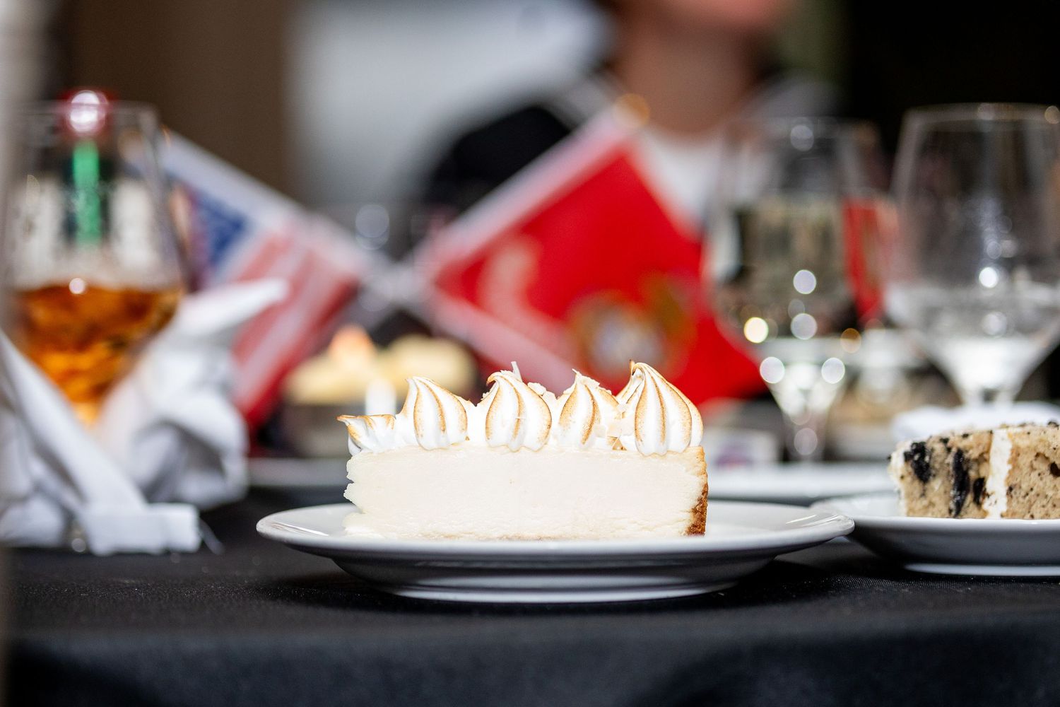 Elegant place settings and desserts displayed on tables at formal military dinner.