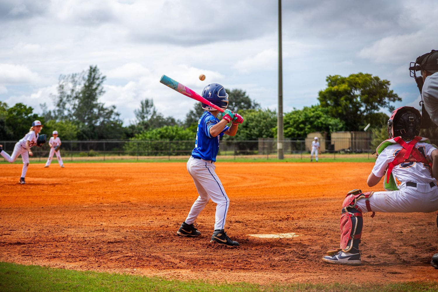 Baseball players in action on a dirt field during a game showing pitching and batting sequences.