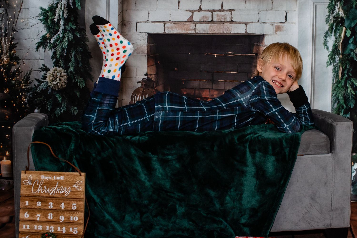 A playful pose on a green velvet couch with holiday decorations in the background.