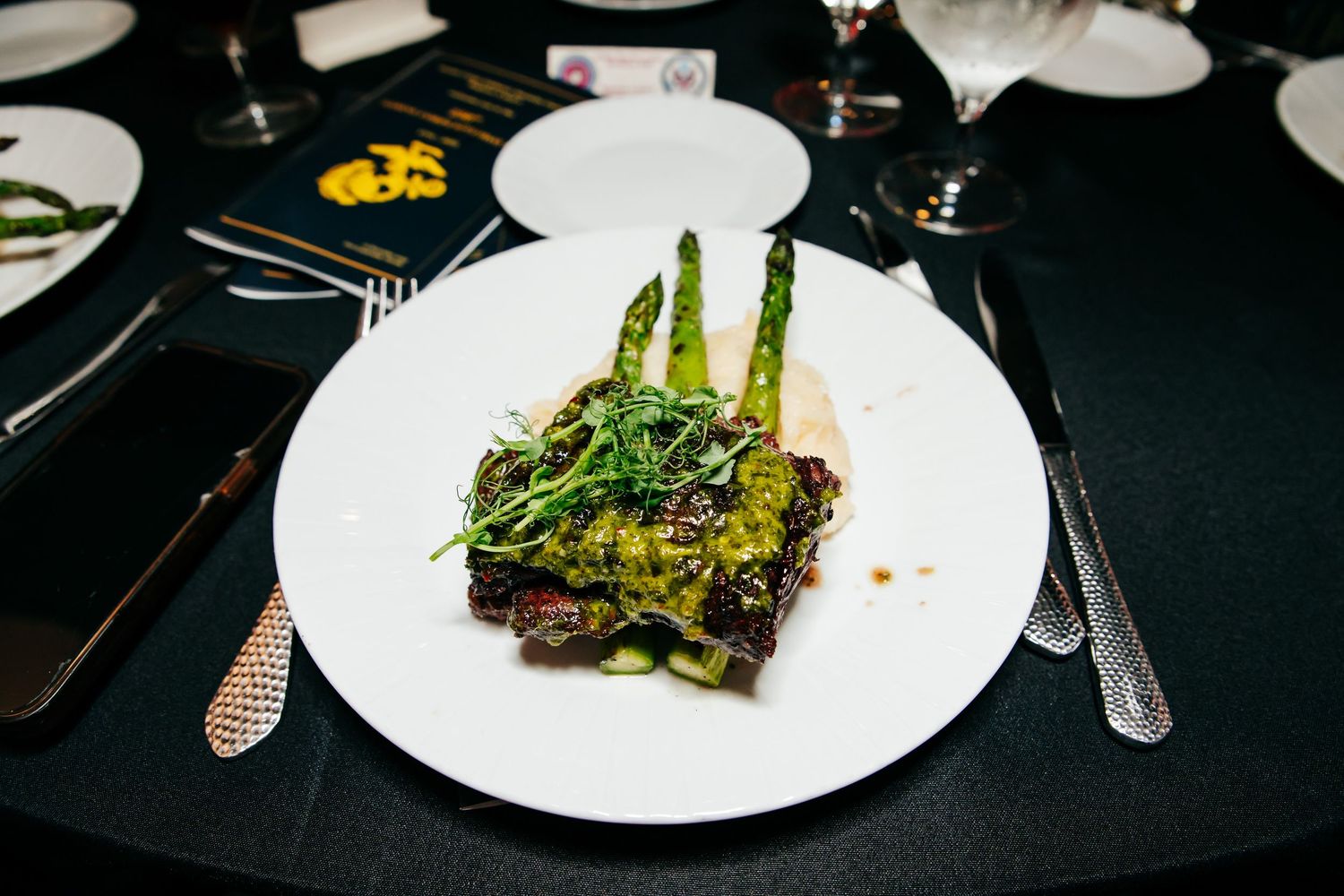 Plated asparagus and gourmet dishes served at formal military dinner event.