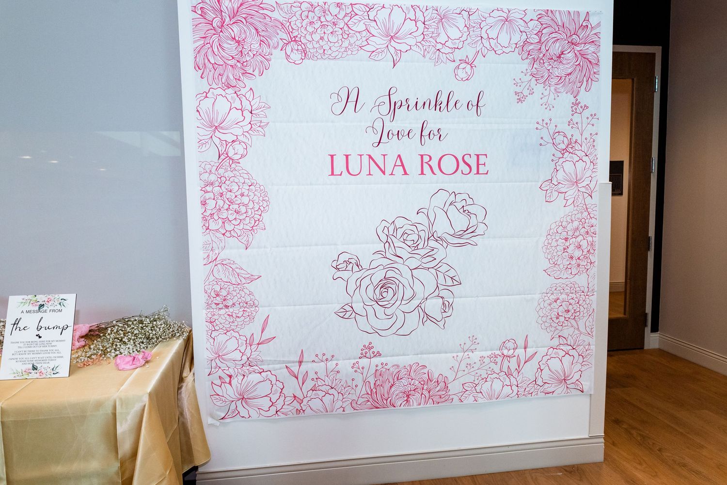 Decorative pink floral text displays and signage with rose designs mounted on a wall.