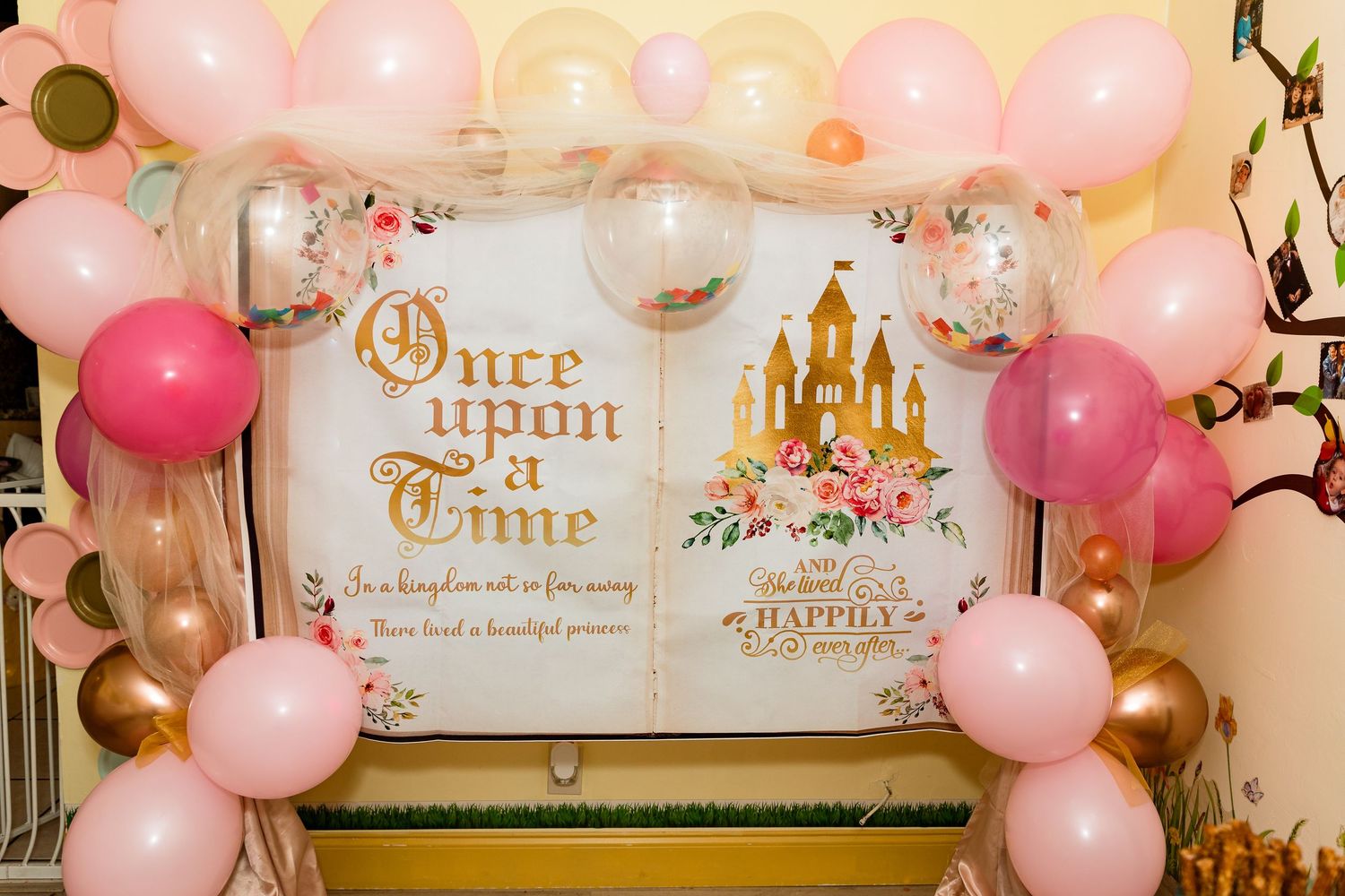 Balloon arch with pink, white and gold balloons framing a princess-themed 'Once Upon a Time' backdrop with castle design.