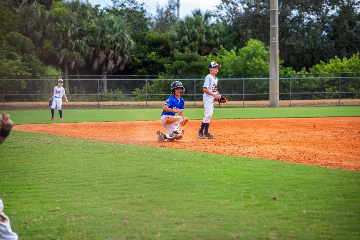 Baseball field with green outfield grass and red clay infield during a game in progress.
