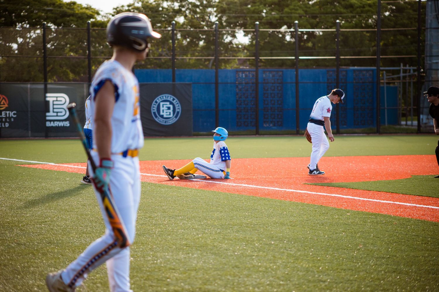 Baseball players warming up on field during practice session with multiple photos showing different training exercises.