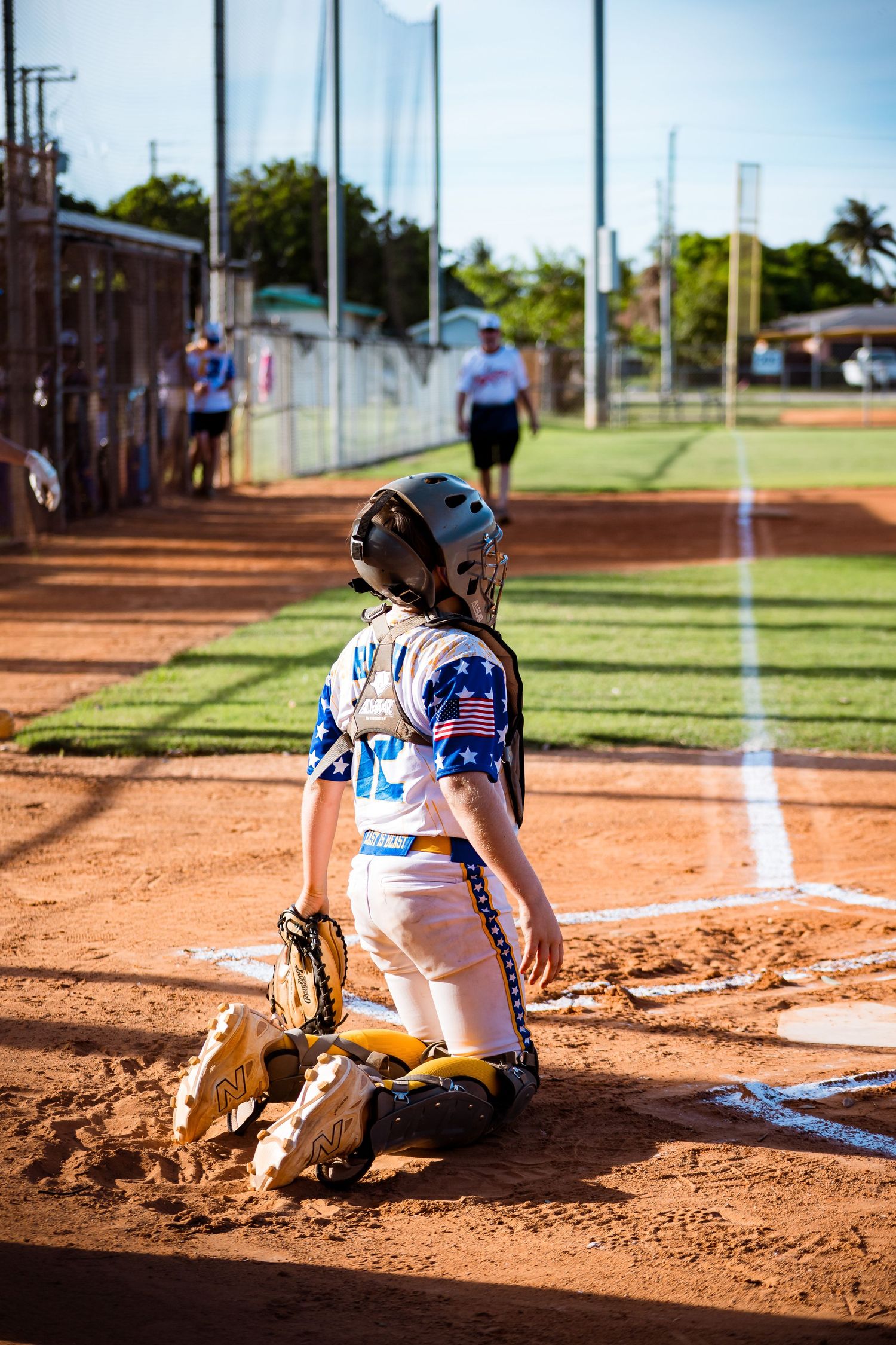 A softball player slides into base on dirt field during a game in a three-frame action sequence.