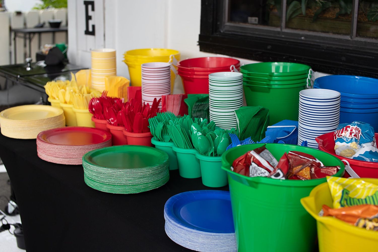 Colorful plastic cups and party supplies arranged on a table for a celebration.