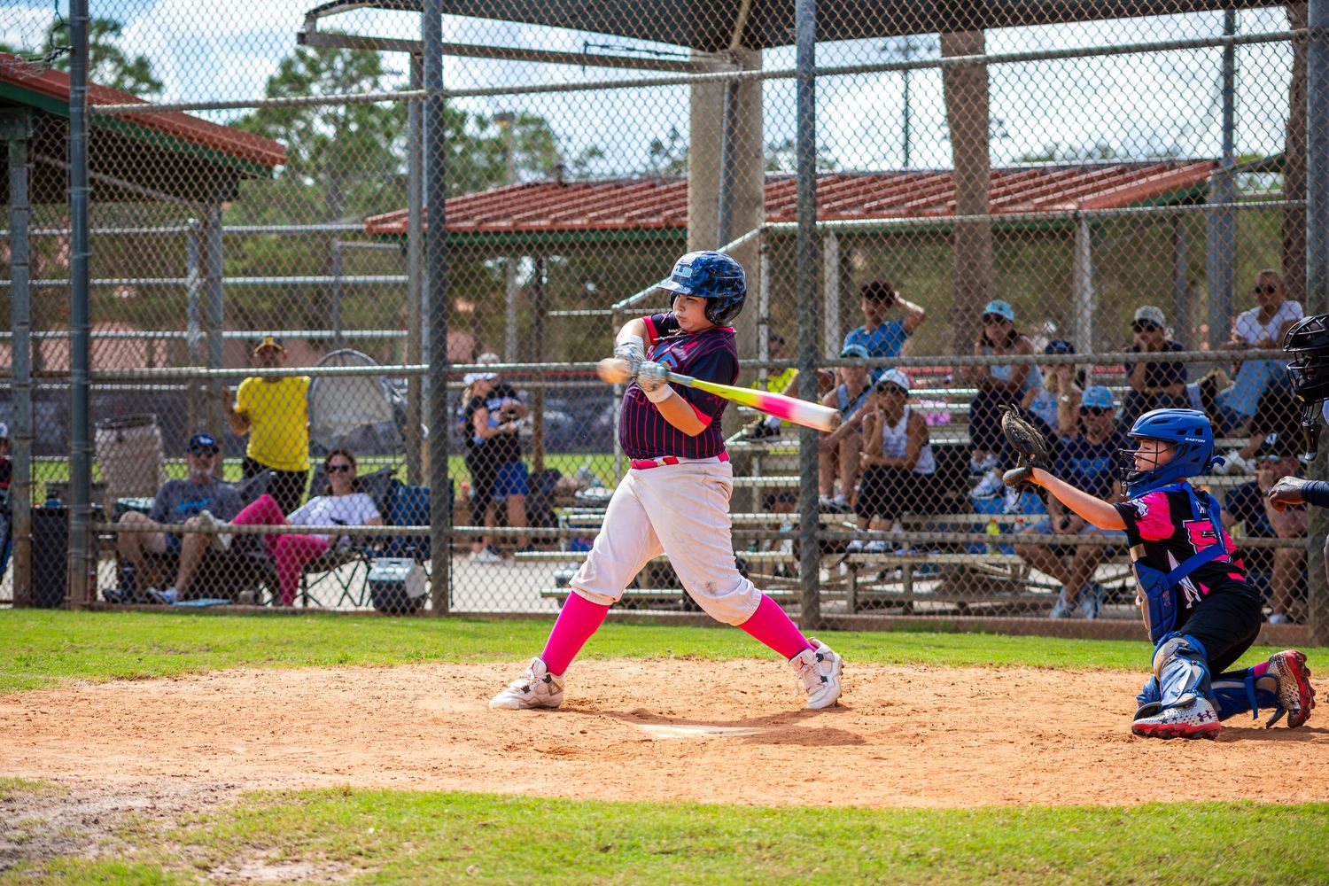 Baseball players in action during a game showing sliding into base and fielding plays on a sunny day.