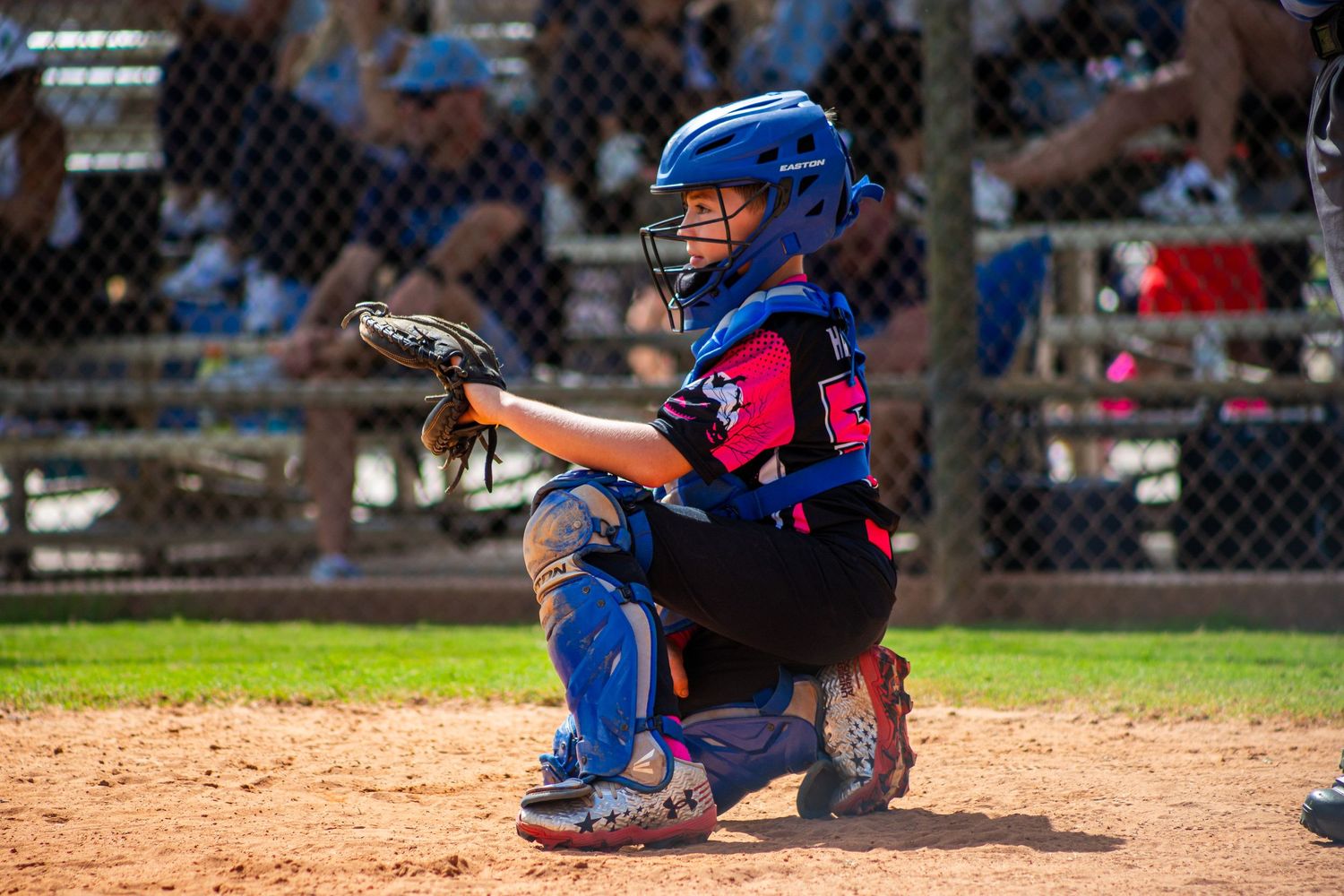 Baseball player swings bat at home plate during competitive game with catcher and umpire behind.