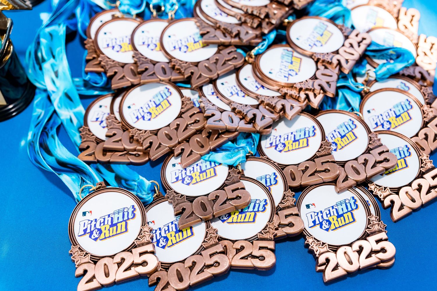 Throughout Run Disney event medals with bronze finish and blue ribbons are arranged in a decorative display pattern.