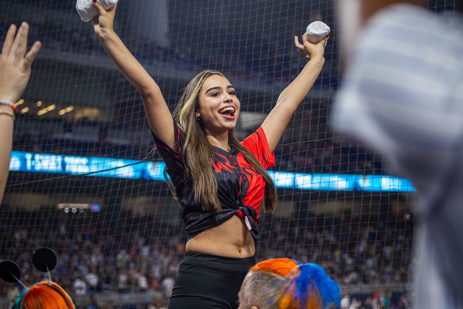 Enthusiastic fans cheer and wave their arms during an exciting baseball game.