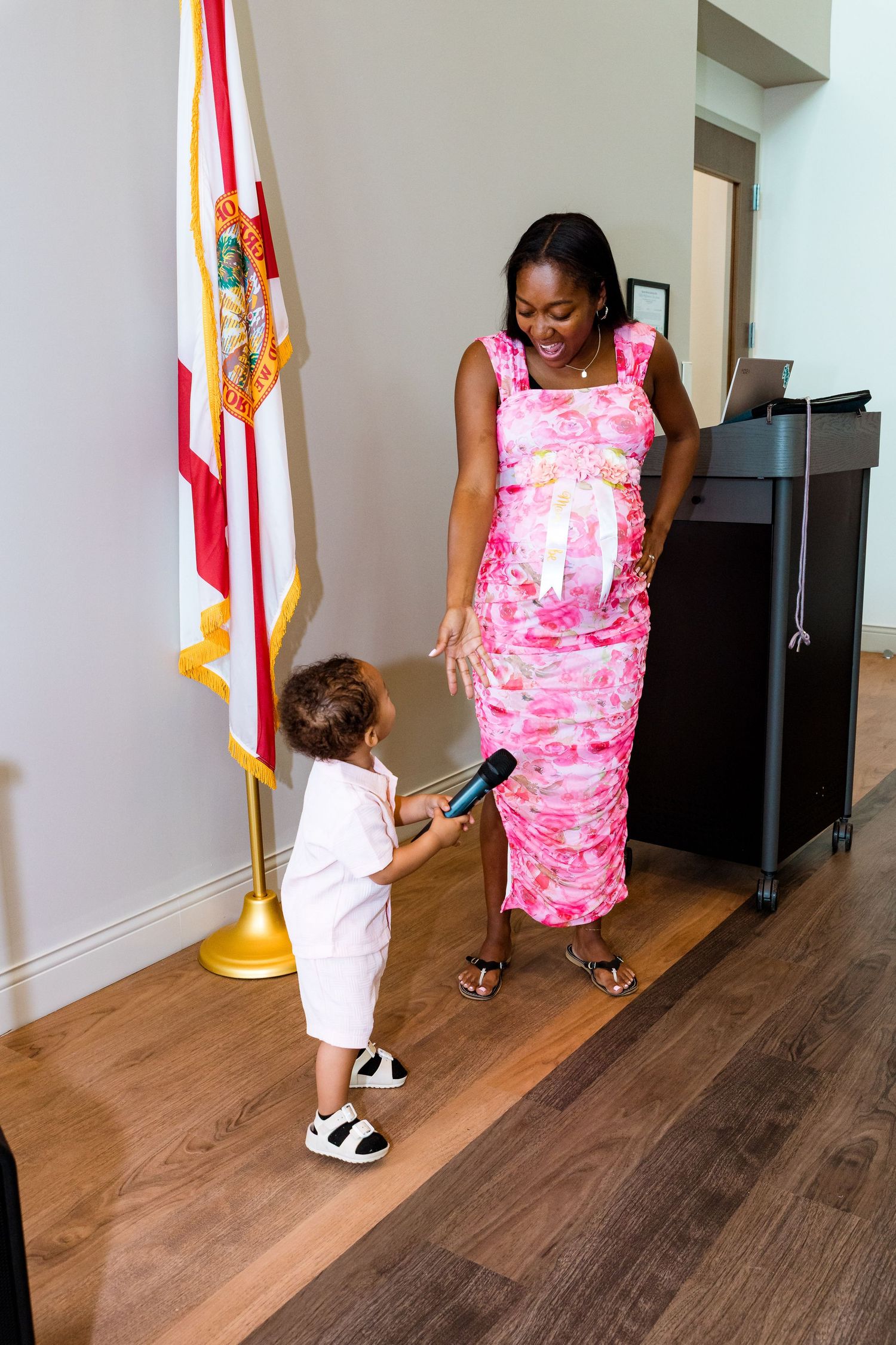A pink floral dress and Florida state flag beside a piano.