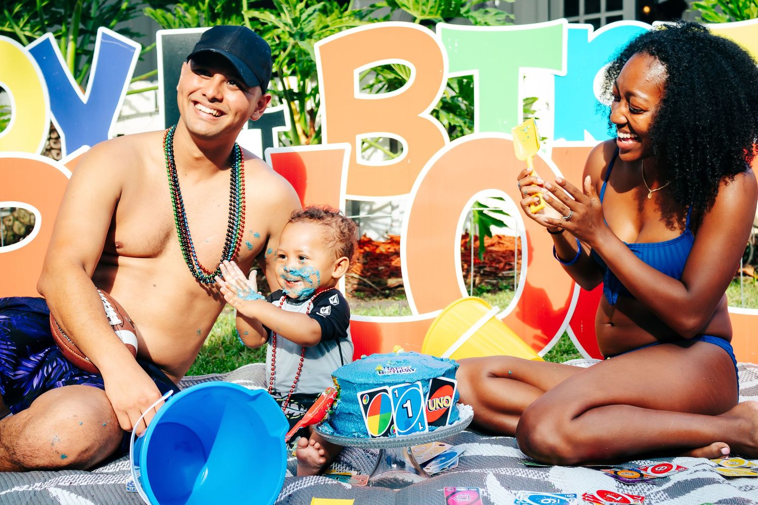 Family enjoying a card game outdoors with colorful decorations.