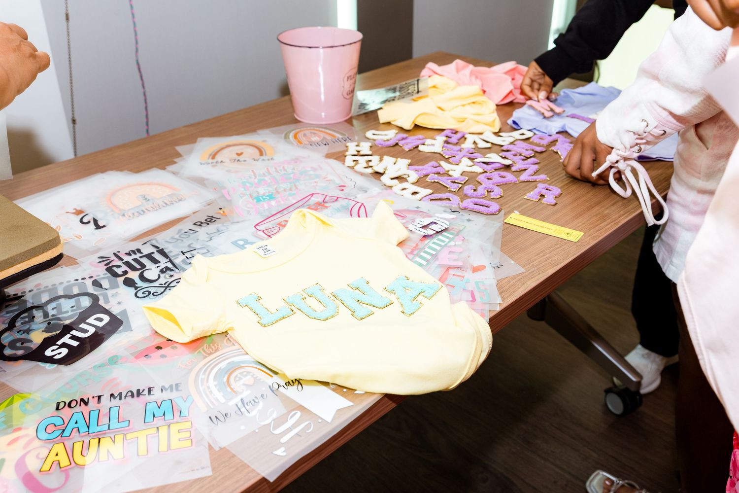 Craft supplies and decorative items spread across table at party gathering.