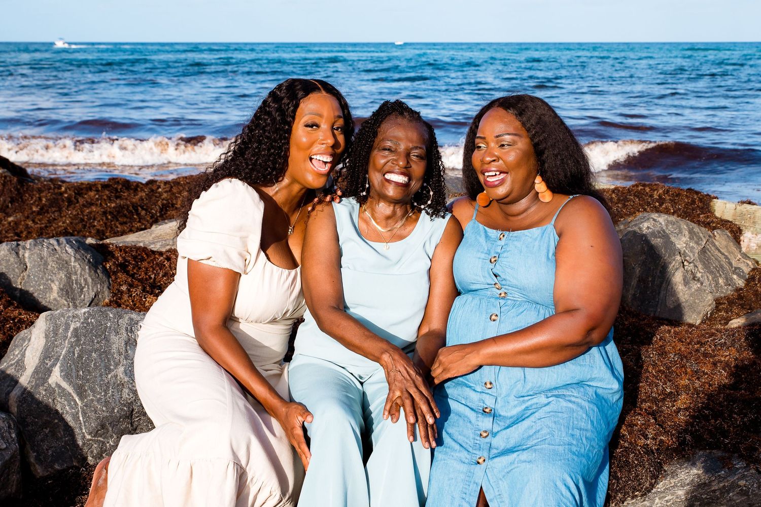 People in light blue outfits sharing candid moments at the beach with ocean view.