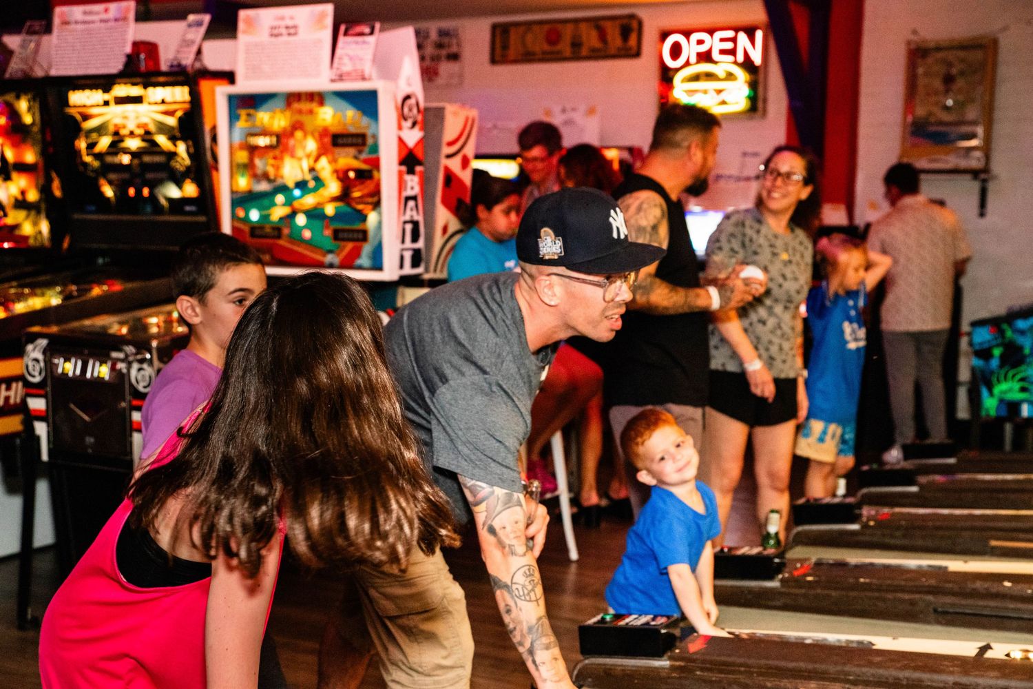 A lively nighttime scene with people gathered outside a brightly lit bar or restaurant.
