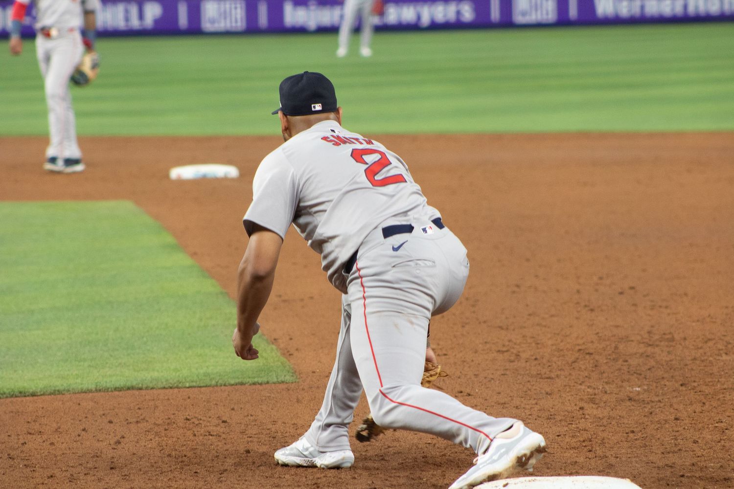 Baseball player in grey uniform positioned at first base during game.