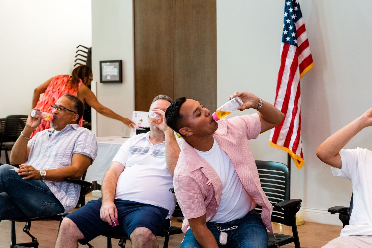 A lively party scene with people enjoying themselves against an American flag backdrop.