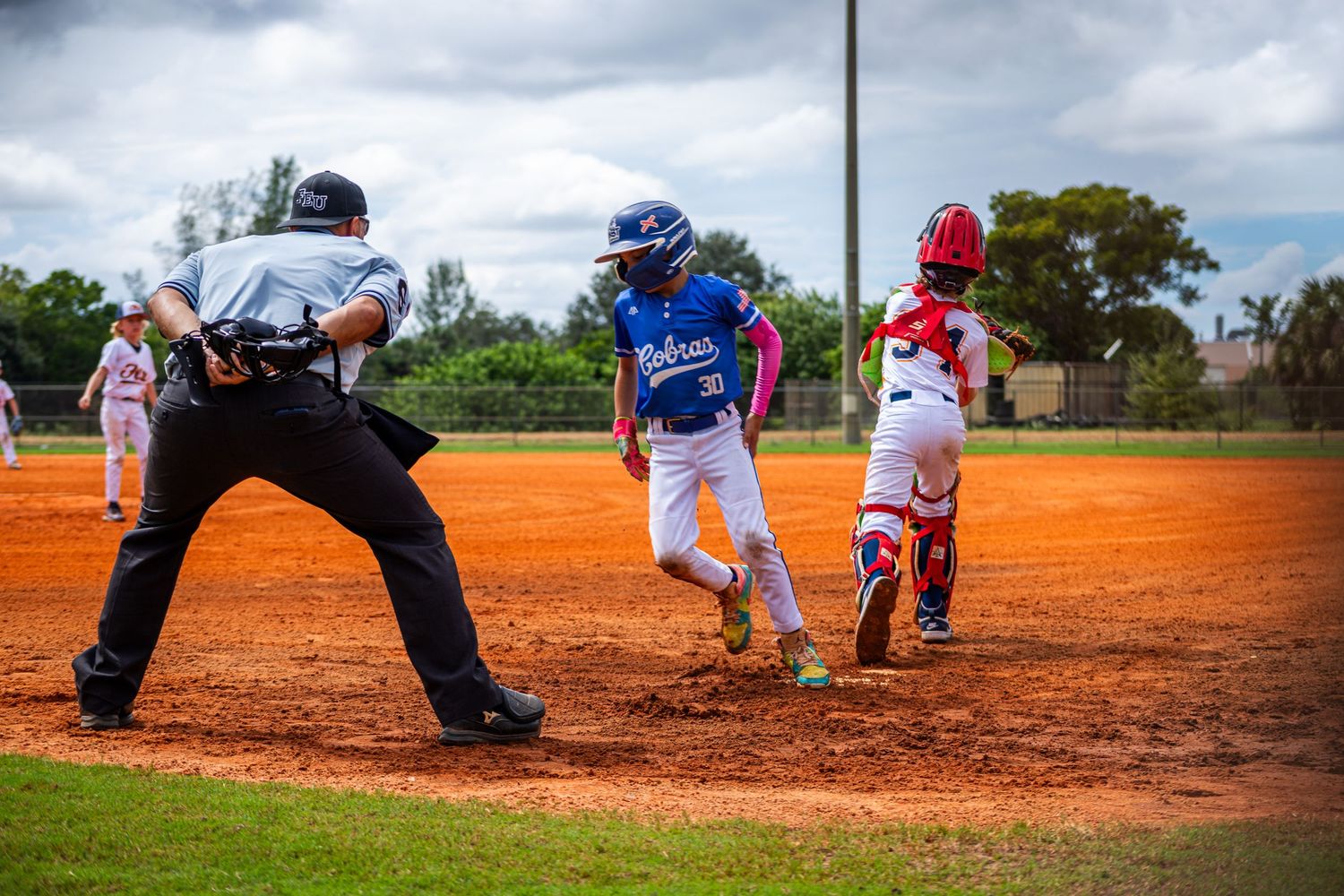 Baseball players in action on a dirt field showing pitching and batting sequences from a lower angle.