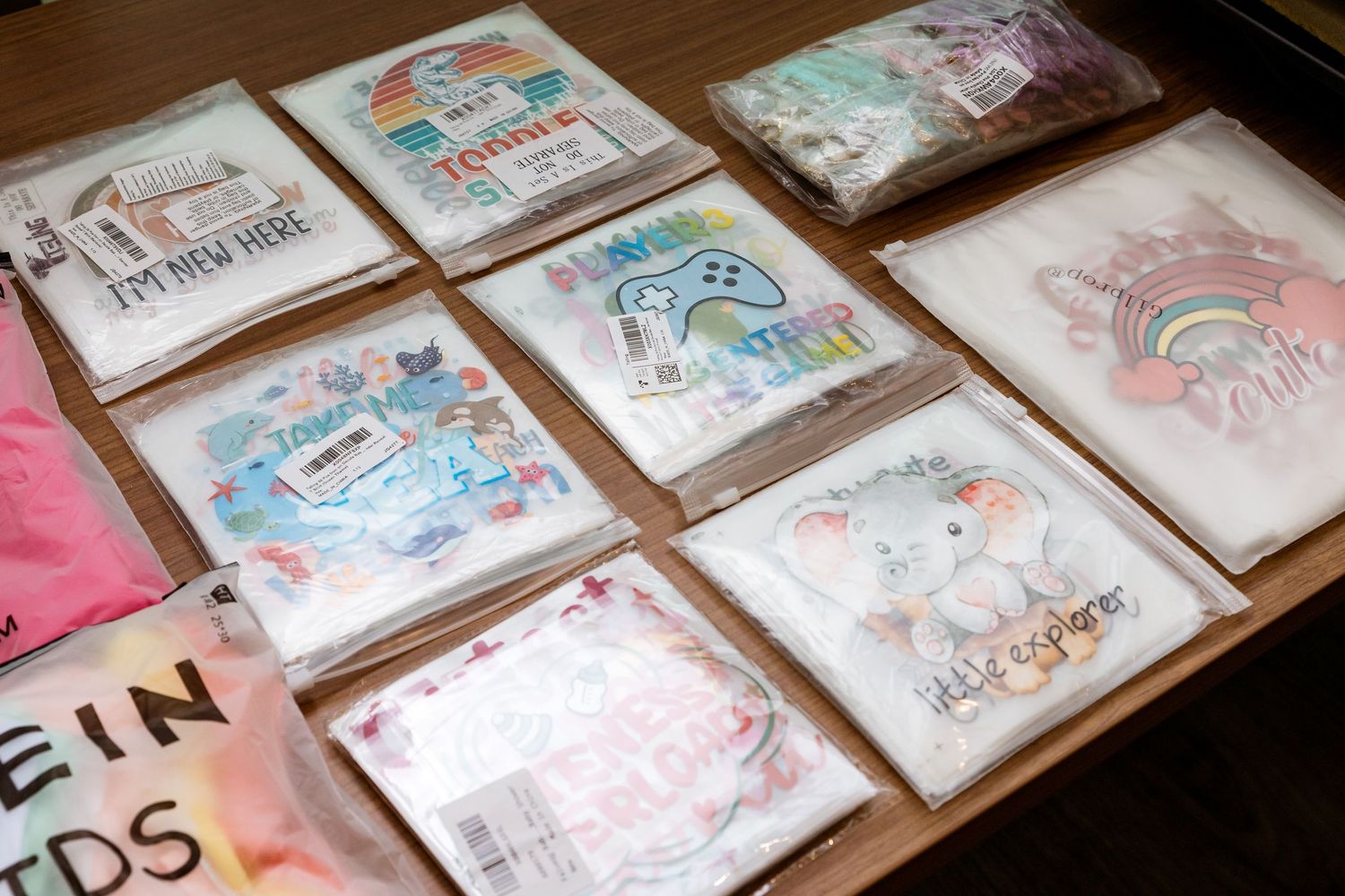 Array of artistic greeting cards with whimsical watercolor designs displayed on a wooden surface.