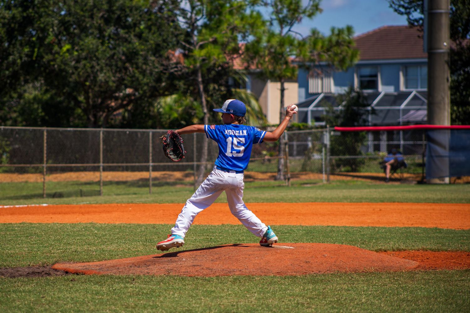 Seven sequential baseball pitching photos showing a pitcher's throwing motion from start to release on a sunny day.