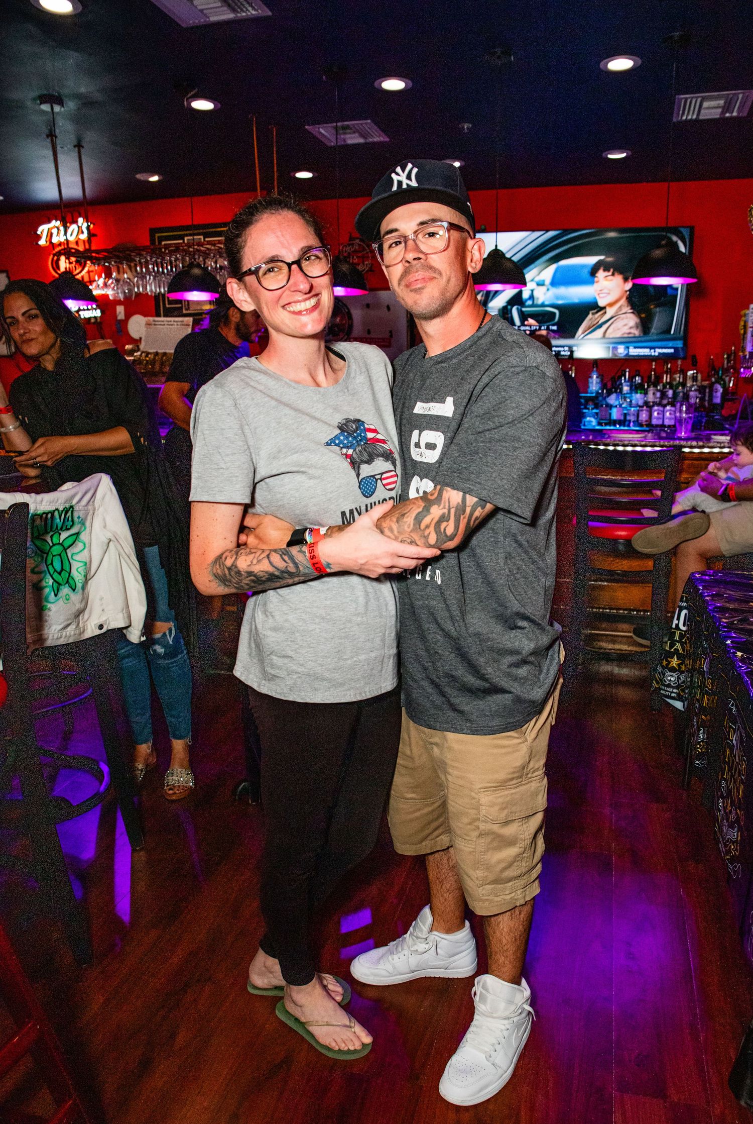 A couple posing for a photo together in a brightly lit and lively entertainment venue.