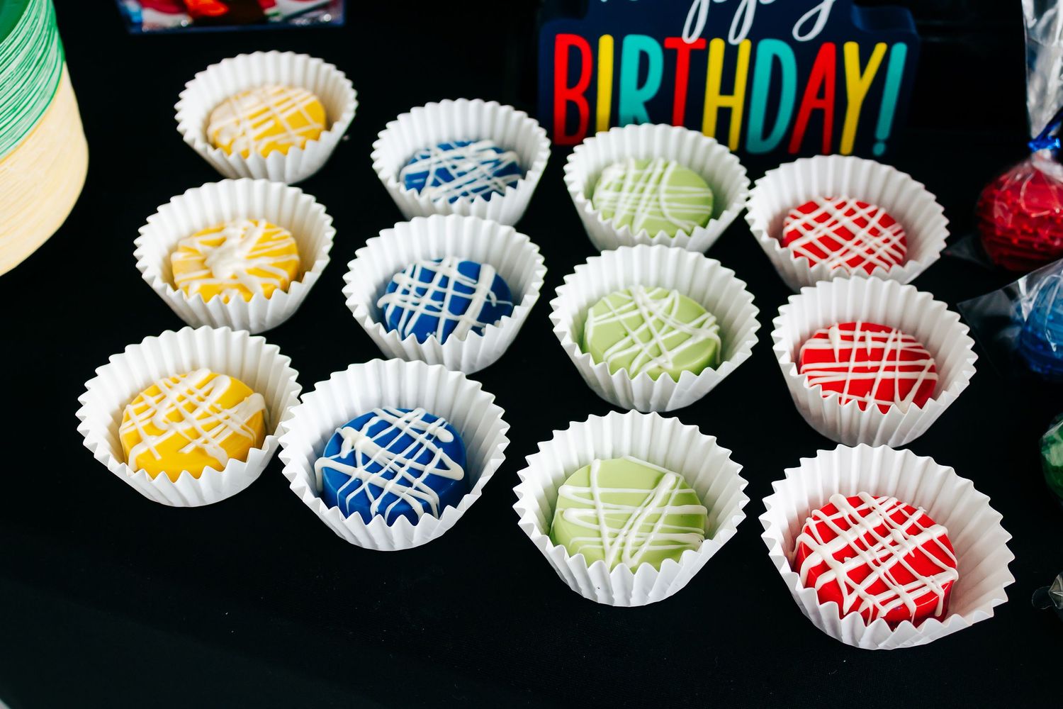 Decorative cupcakes with colorful frosting and sprinkles arranged in rows.