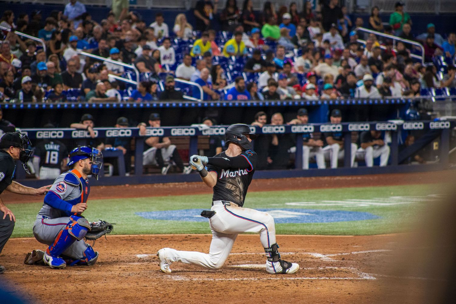 Multiple baseball players in action at home plate during a close play.