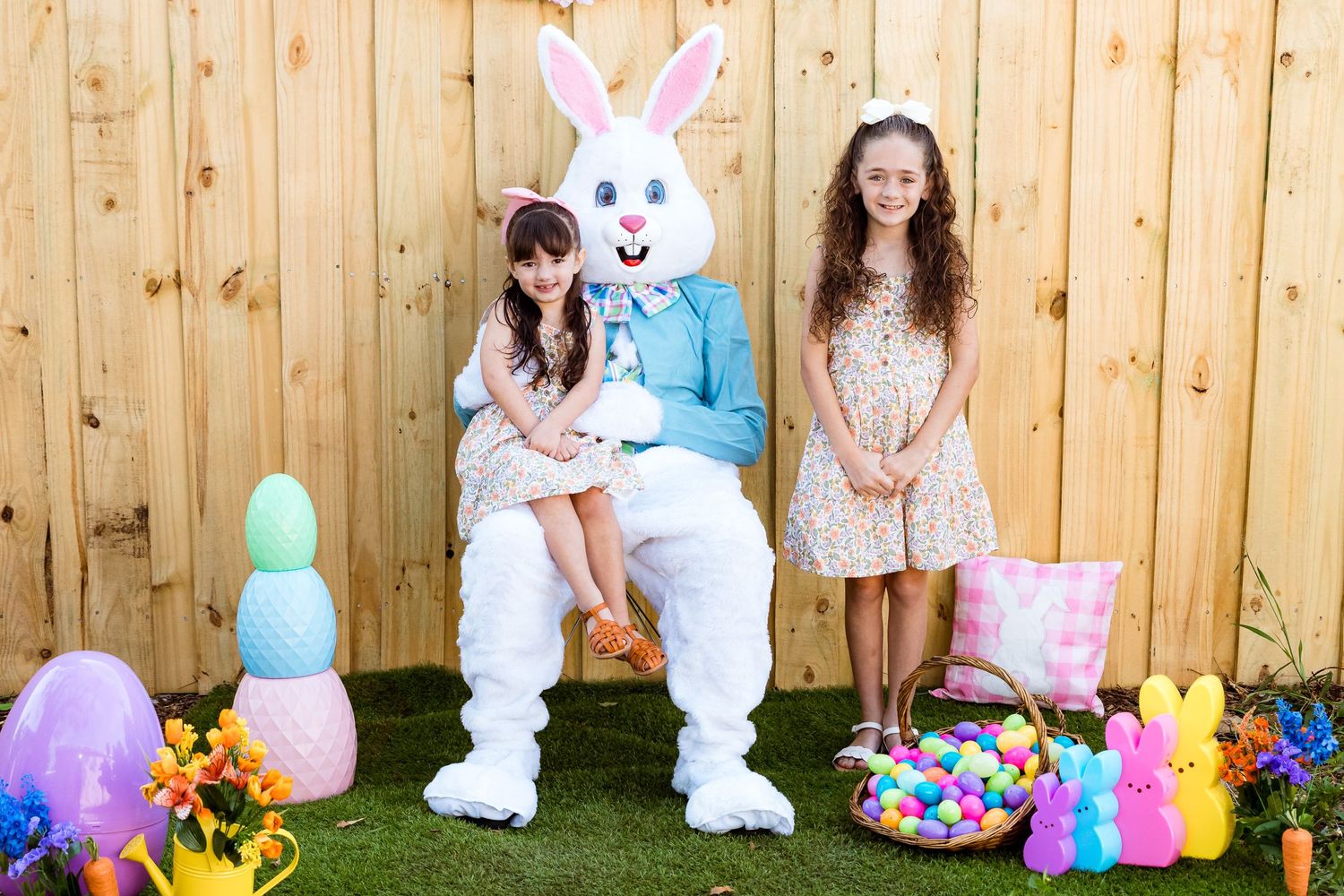 Easter bunny character posing with visitors amid spring decorations and colorful eggs.