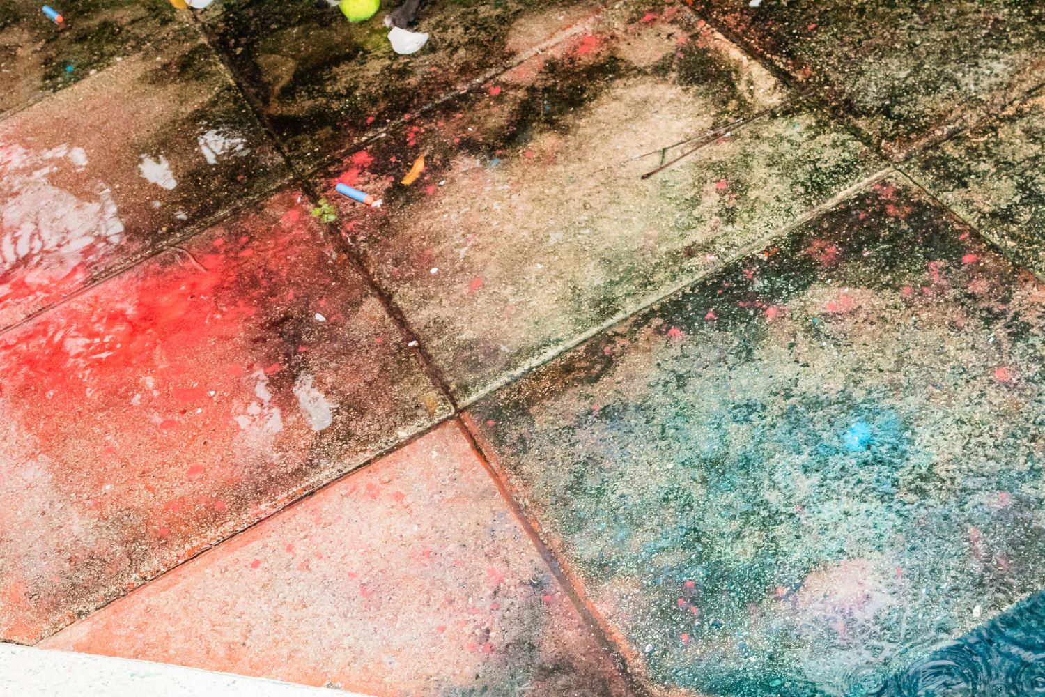 Colorful powder residue on ground showing pink and blue from gender reveal celebration.