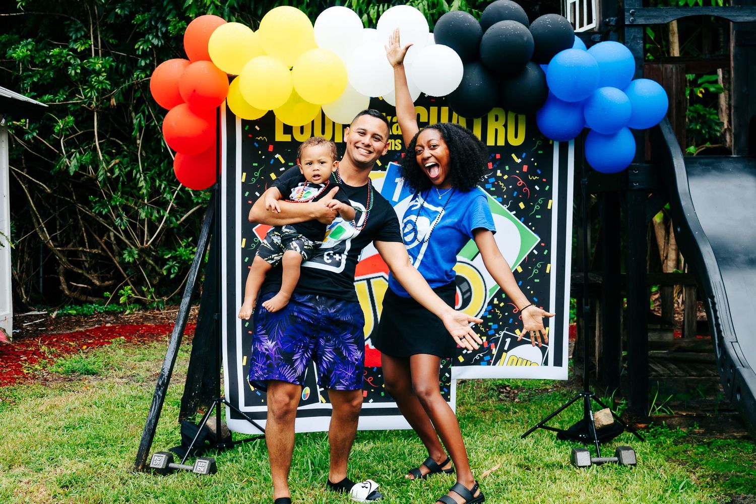 Festive party scene with rainbow balloon arch and backyard decorations.