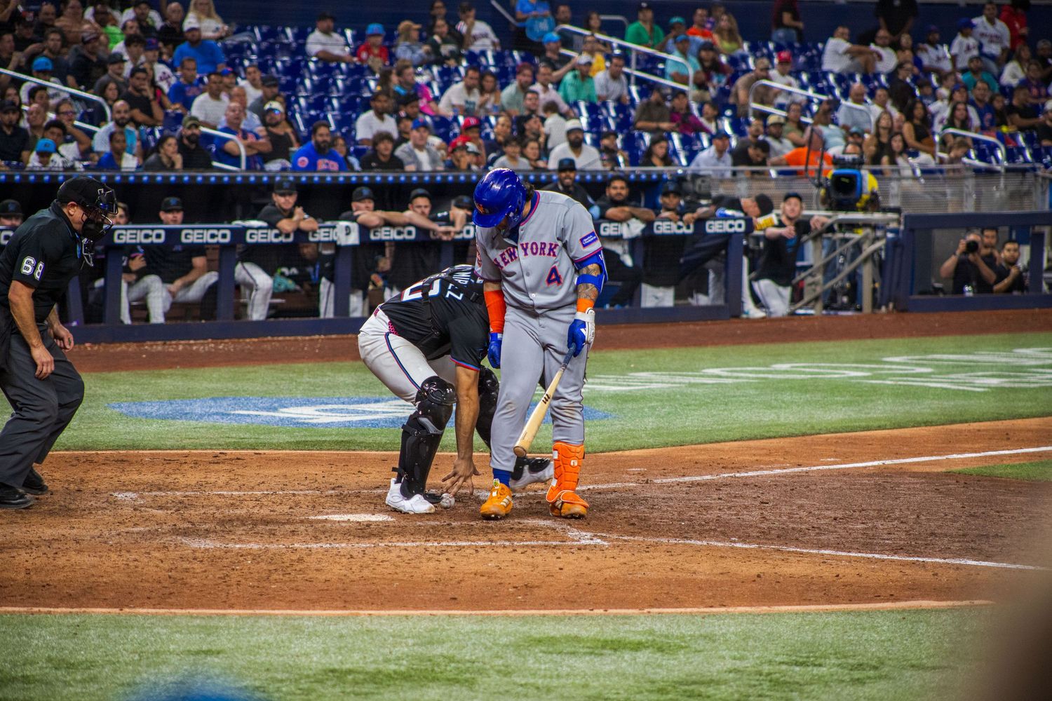 Baseball game action shot with players and crowd visible at professional stadium.