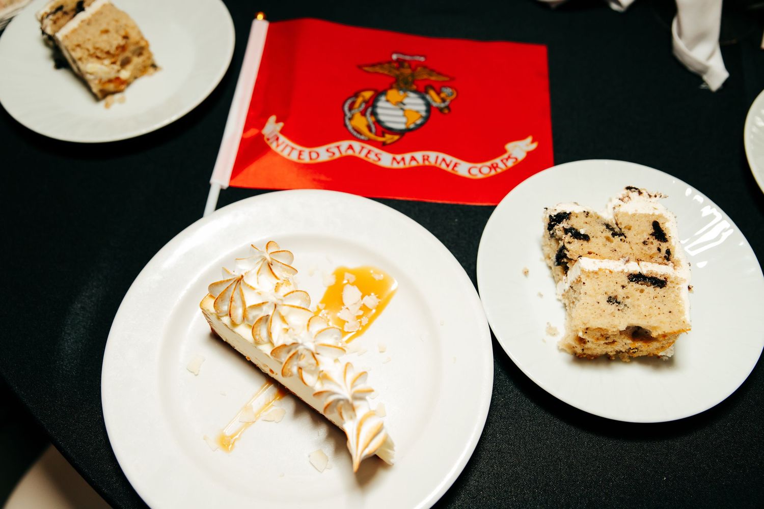 White dessert plates with various pastries and treats featuring Marine Corps logos and decorations.