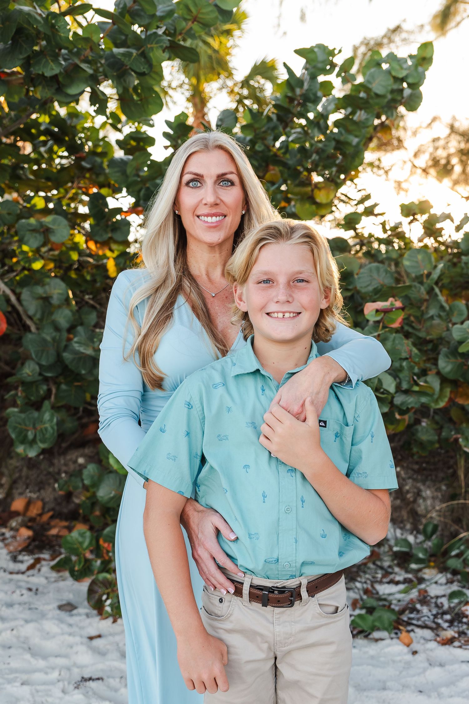 Family portrait on beach with coordinating mint and light blue outfits.