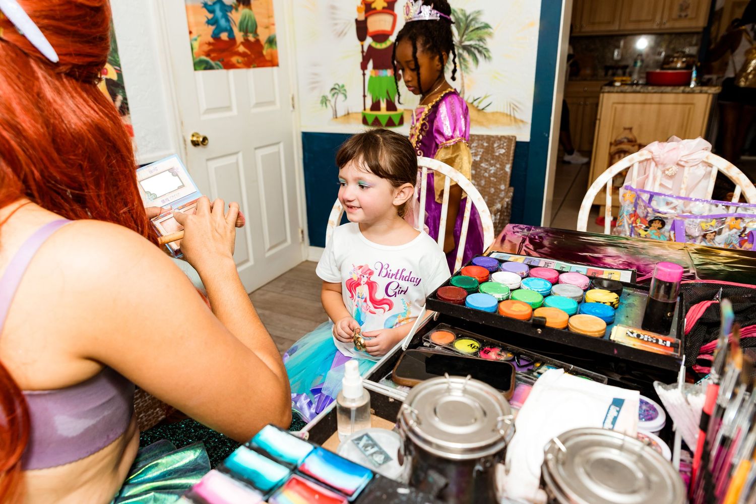 Colorful cupcake decorating station set up at a children's themed birthday party with pastry supplies.