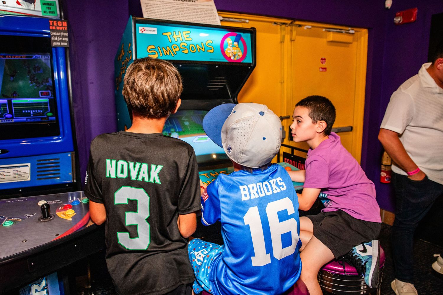 Two children playing video games in an arcade.