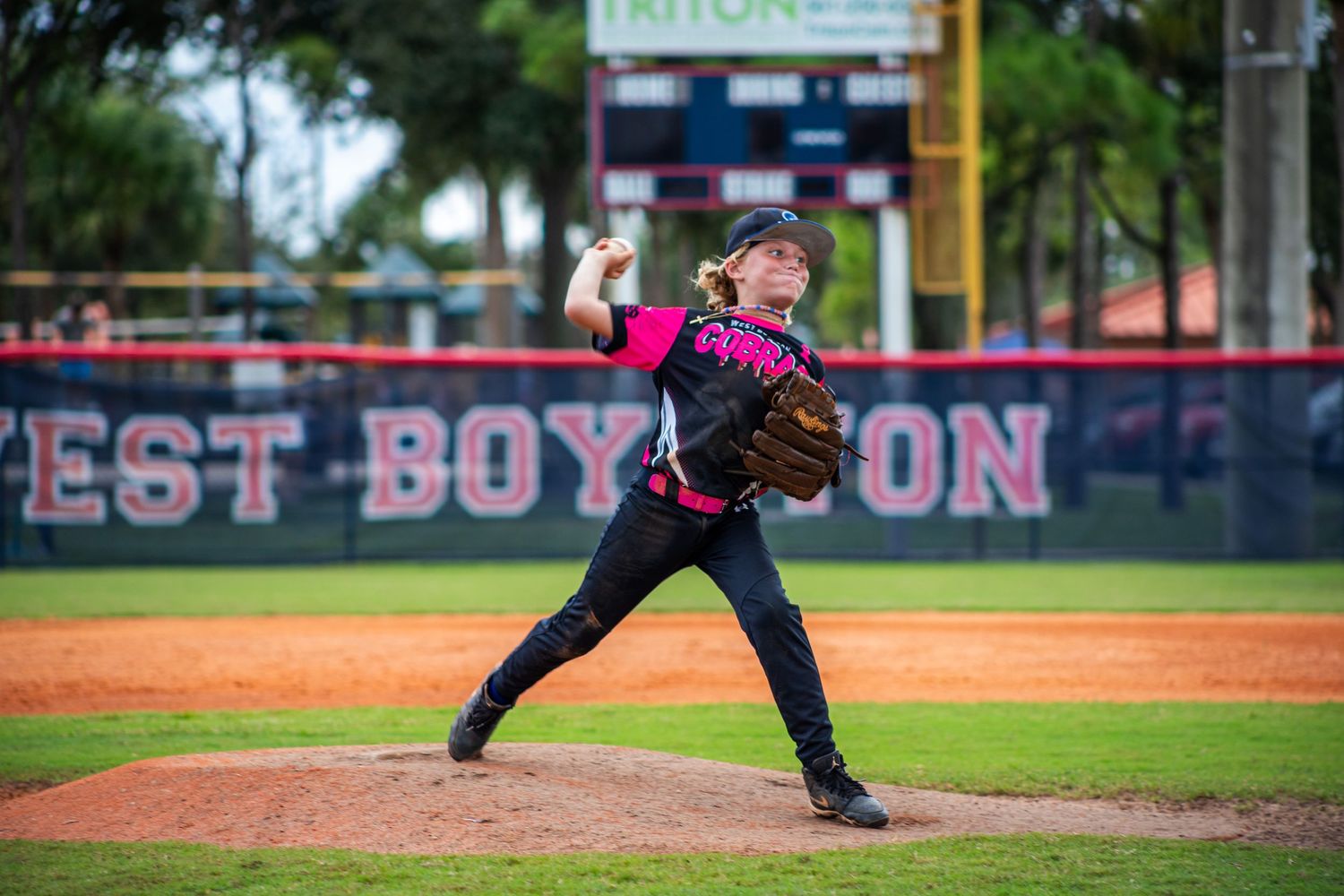 Baseball player in motion delivers pitch from mound during competitive game.