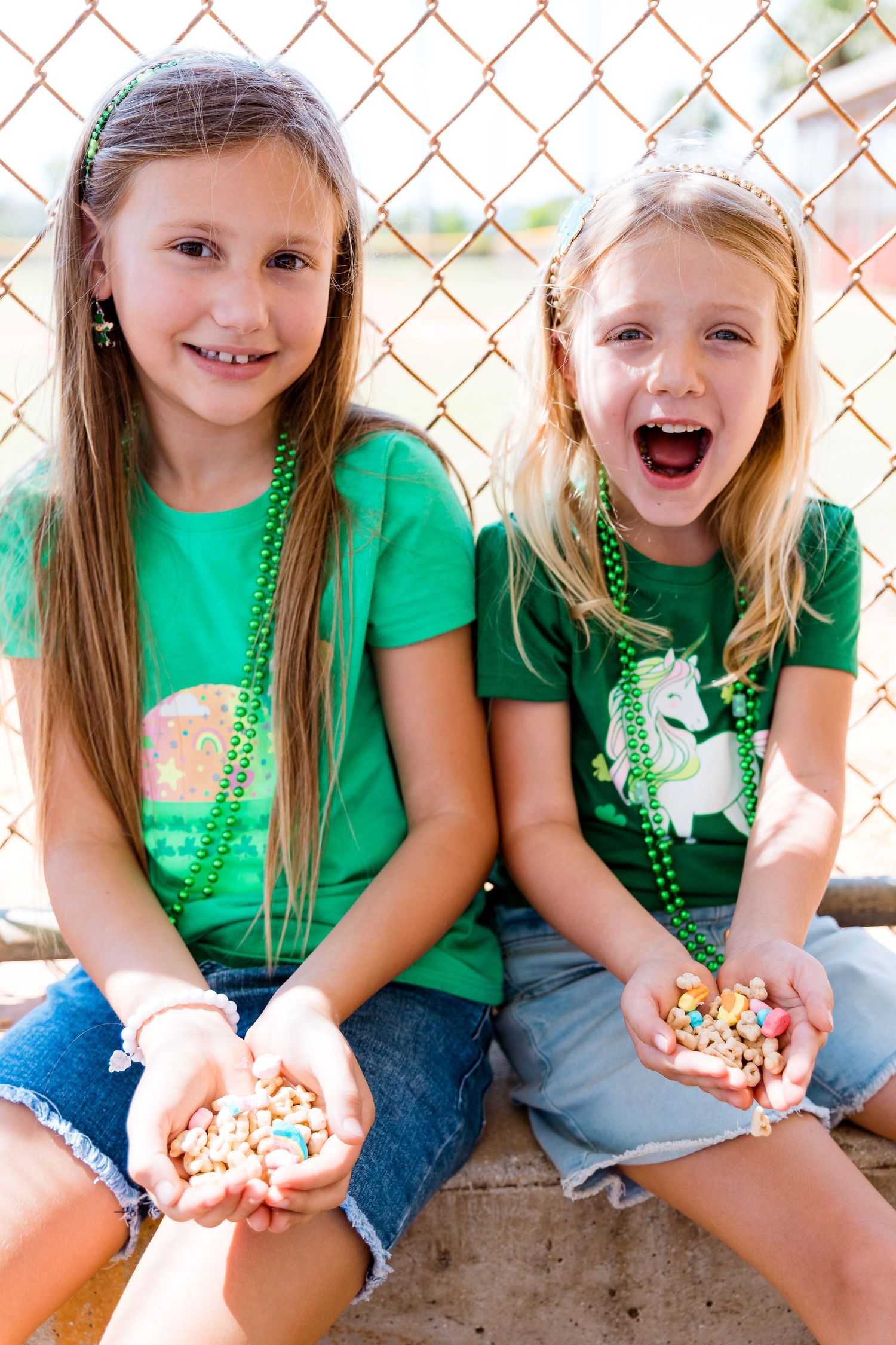 Children wearing green shirts and beaded necklaces showing excitement over lucky charms.